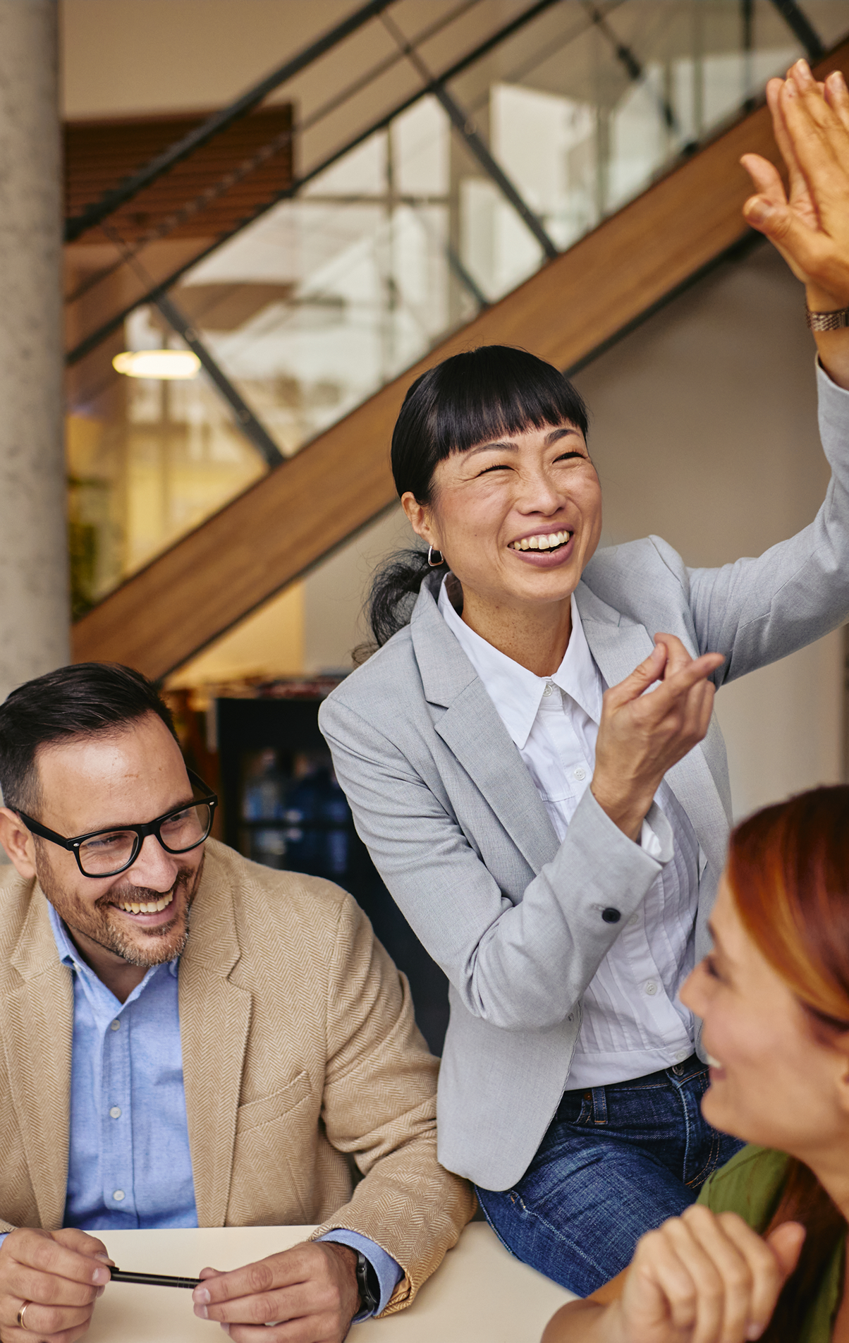 Three employees celebrate at an office